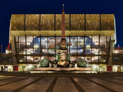 Blick auf den beleuchteten Mendebrunnen und das beleuchtete Gewandhaus zu Leipzig am Augustusplatz am Abend in dem das berühmte Gewandhausorchester spielt und das eine wahre Sehenswürdigkeit der Musikstadt Leipzig ist, Kultureinrichtung